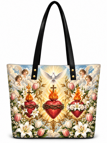 A tote bag with black shoulder straps and a detailed religious art print featuring Sacred Heart of Jesus imagery, cherubs, lilies, and doves on a white background.