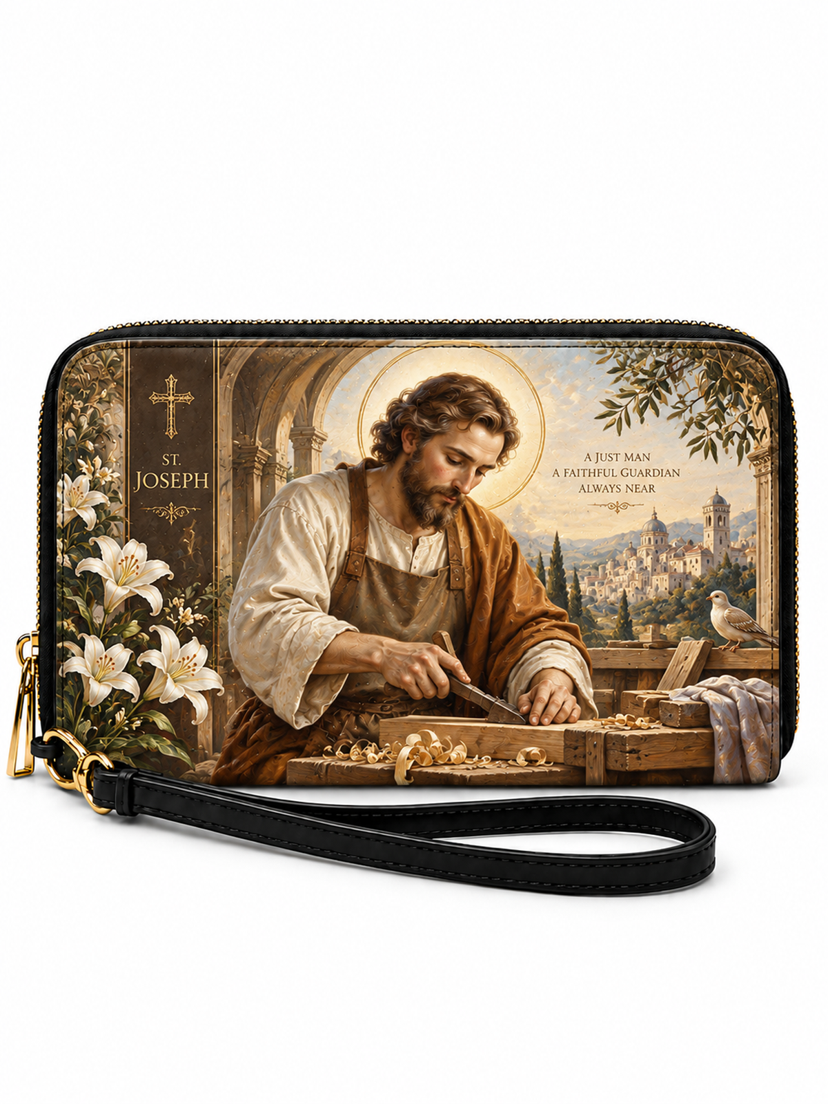 A zip-around wristlet clutch featuring a printed religious illustration of Saint Joseph working in a woodshop, with white lilies on the left, a cross and his name on the left side, and a black wrist strap with gold-tone hardware in front.