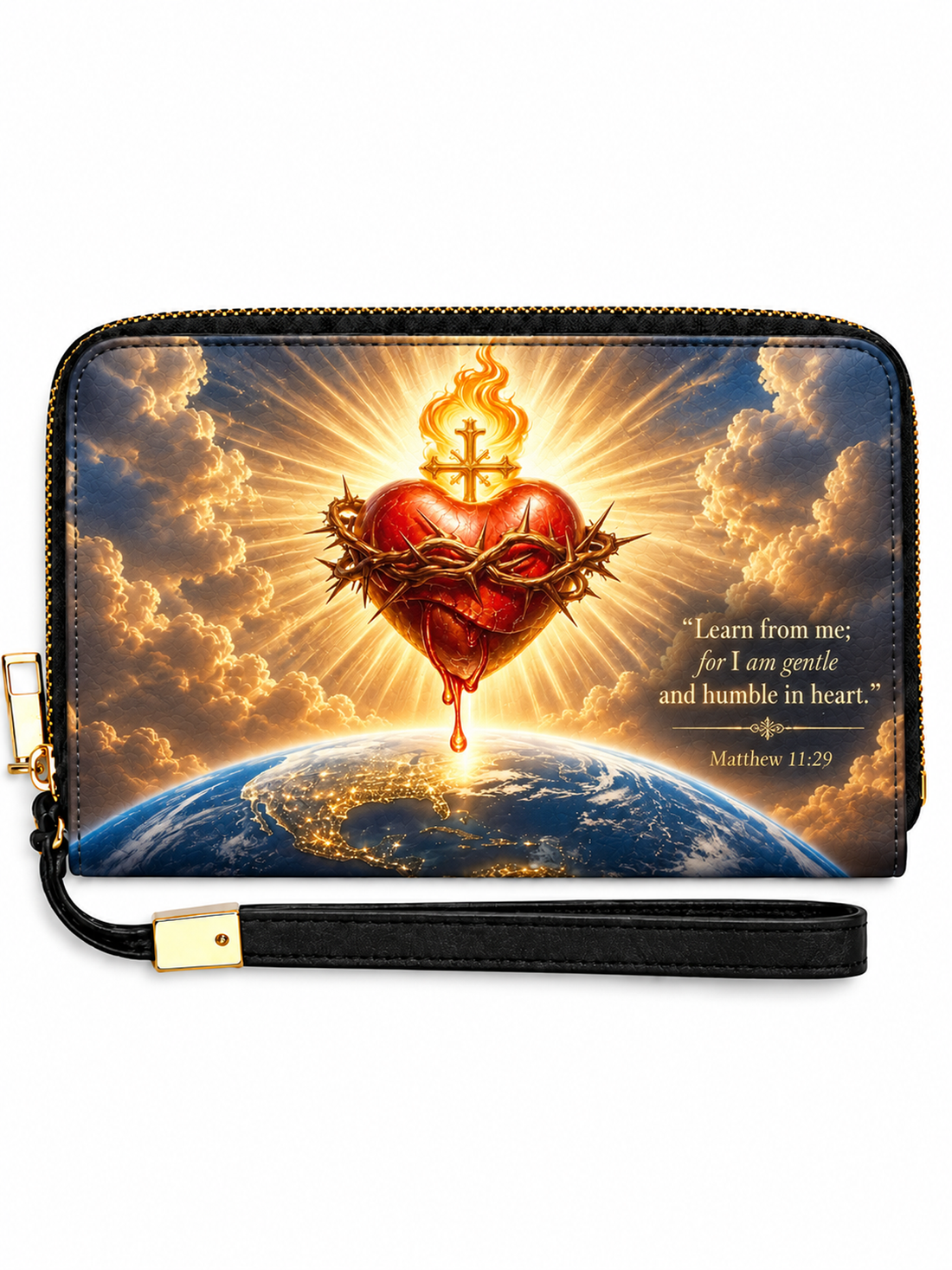 A zip-around wristlet clutch with a black wrist strap and gold-tone hardware, featuring a printed graphic of a crown-of-thorns sacred heart on a flaming red heart above a globe, with golden clouds and a Bible verse on the right side.