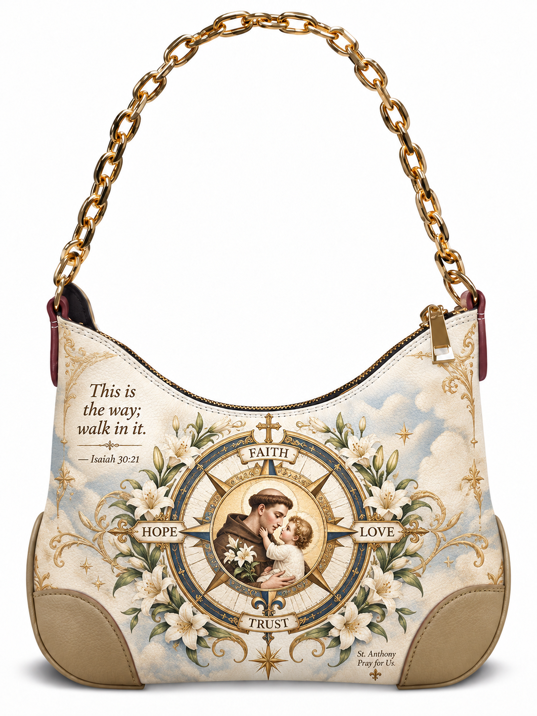 A hobo-style shoulder bag with a gold chain strap, featuring a religious graphic print of St. Anthony Pray for Us with lilies, a compass rose, and the quote 'This is the way; walk in it.