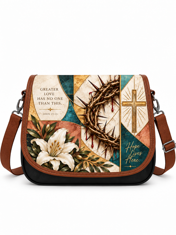 A rectangular shoulder bag with a brown leather trim and a black base, featuring a vintage-style collage print with a white lily, a crown of thorns, a gold cross, and religious text including 'Greater Love Has No One Than This, John 11:13' and 'Hope Lives Here'.