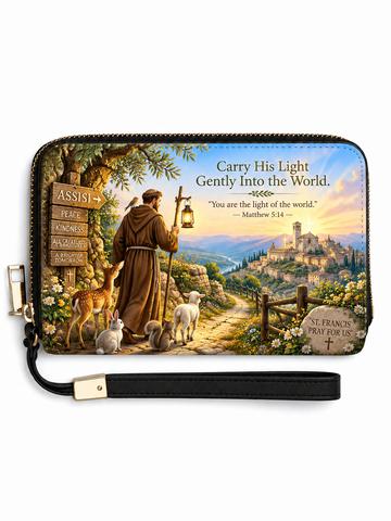 A rectangular zip-around wristlet wallet with a black wrist strap, featuring a colorful printed illustration of Saint Francis of Assisi with deer, a shepherd, a signpost, and a scenic landscape. The text on the design reads, 'Carry His Light Gently Into the World.