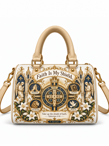 A structured cream-colored handbag with a detailed religious crest design featuring gold, navy blue, and white elements, with the text 'Faith Is My Shield' and 'Ephesians 6:14' printed on the front. The bag has top handles, a shoulder strap, and gold-tone hardware, shown against a plain white background.