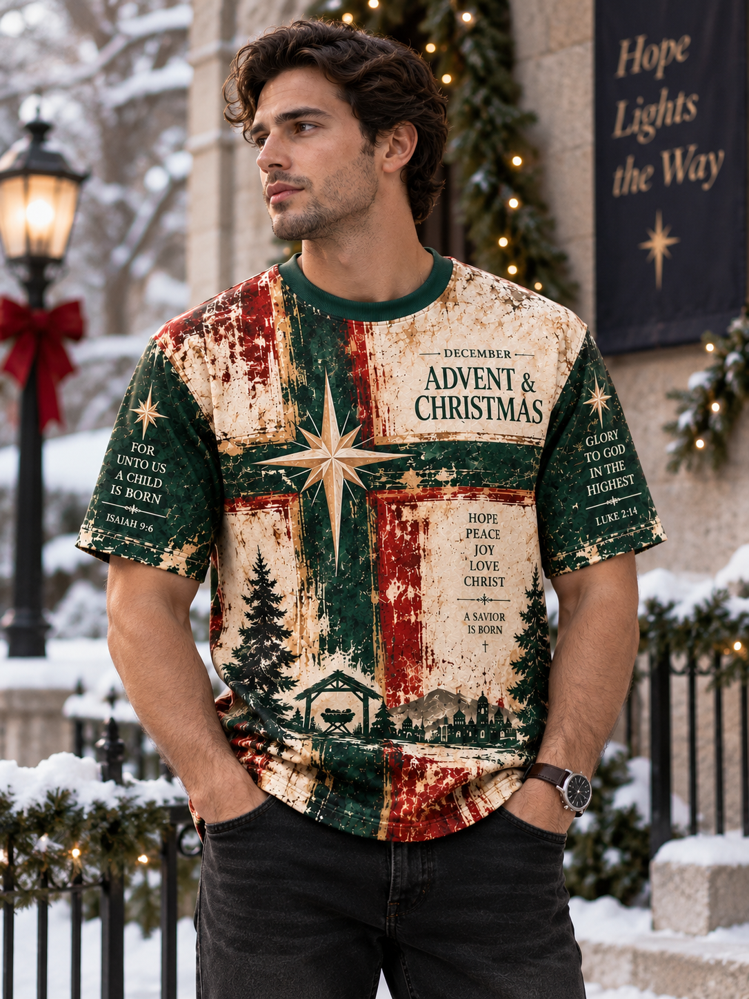A man wearing a distressed Christmas-themed graphic t-shirt with 'Advent & Christmas' text, a green cross, and holiday illustrations, standing in a snowy outdoor setting decorated with lights and garlands.