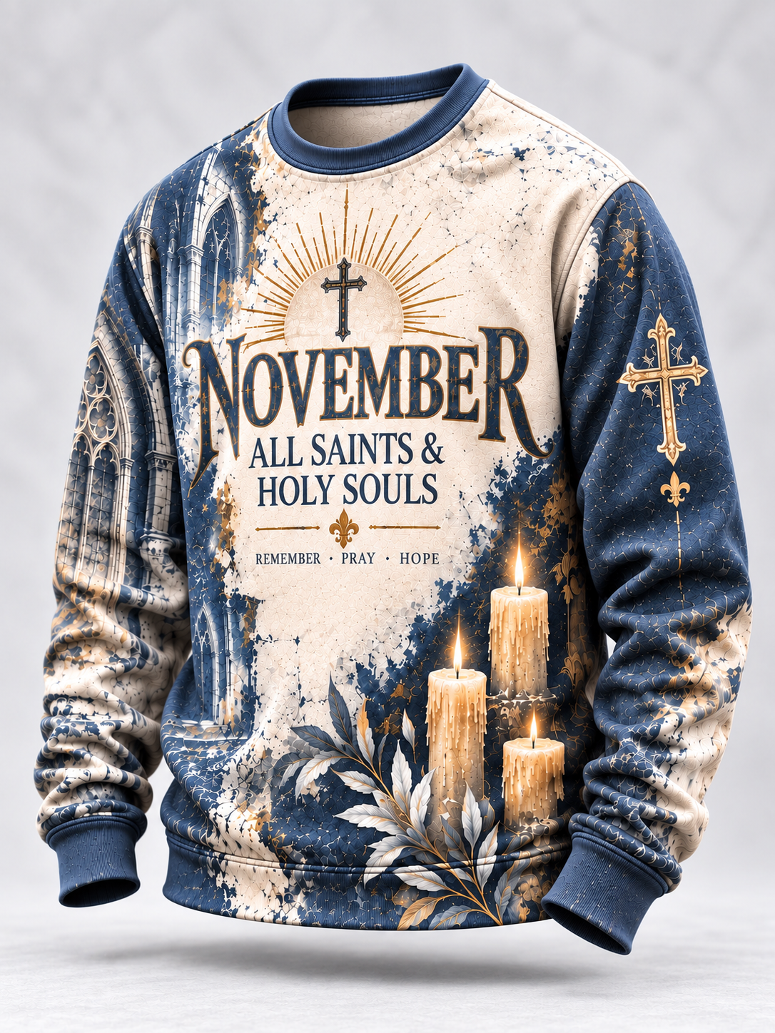 A long-sleeve crewneck sweatshirt with a distressed, vintage-style print. The design features a cream-colored torso with a large graphic reading 'NOVEMBER ALL SAINTS & HOLY SOULS' under a cross and sunburst, and a blue-gray distressed sleeve and side panels with a cross, candles, and religious motifs.
