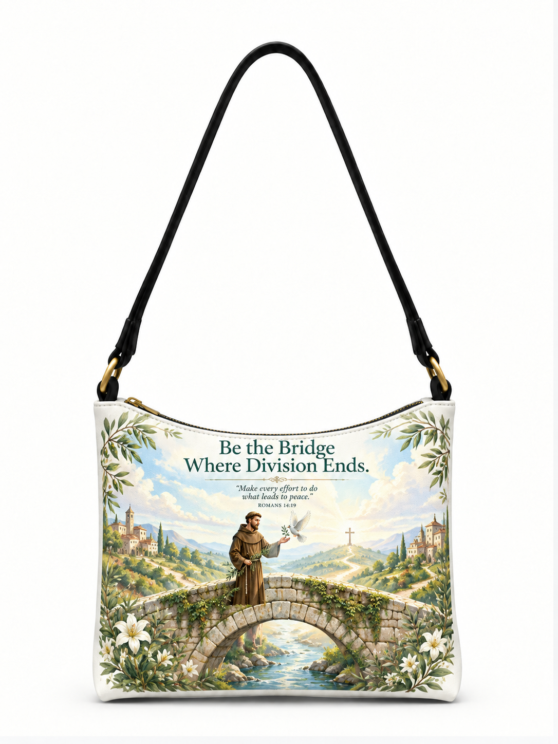 A white shoulder bag with a black strap and gold-tone hardware, featuring a printed graphic of a saint standing on a stone bridge over a river, surrounded by white lilies and green foliage. The text above reads, 'Be the Bridge Where Division Ends.