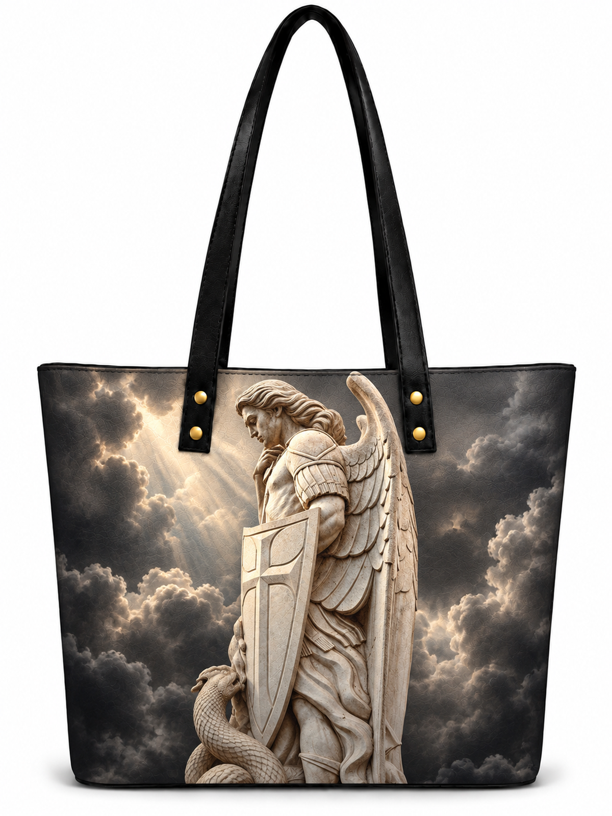 A black tote bag with long shoulder straps, featuring a printed graphic of a stone angel statue holding a shield against a dramatic cloudy sky. The bag has gold-tone rivets at the strap attachments and is shown on a plain white background.