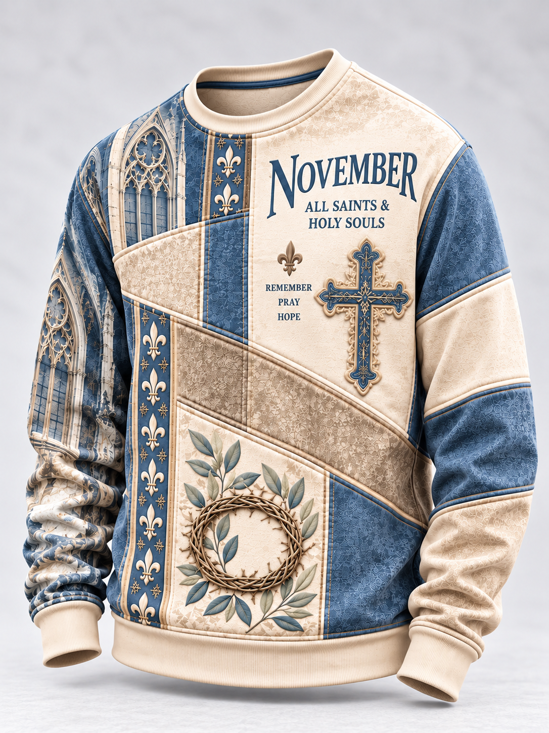 A long-sleeve crewneck sweatshirt with a vintage-style patchwork design in beige and blue. The front features the text 'NOVEMBER ALL SAINTS & HOLY SOULS', a blue cross, a floral crown of thorns, and fleur-de-lis motifs.