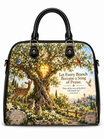 A structured black leather handbag with gold-tone hardware, featuring a large printed scenic design on the front. The artwork depicts a sunlit tree with white blossoms, a deer, rabbits, birds, and a mountain village, alongside the text 'Let Every Branch Become a Song of Praise' and scripture reference Psalm 96:52.