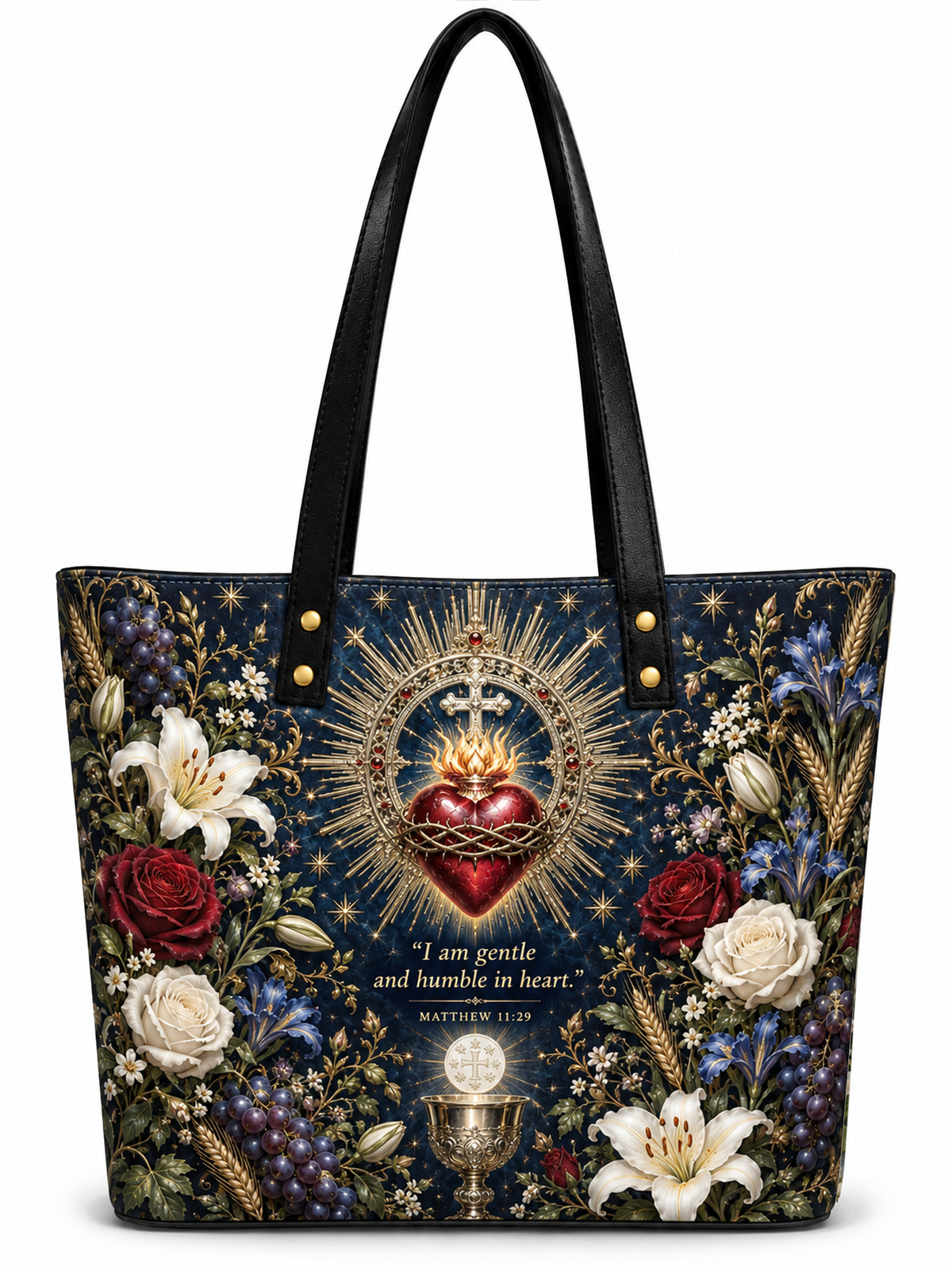A structured tote bag with black leather handles and a dark navy blue body, decorated with a detailed Sacred Heart of Jesus illustration, surrounded by red and white roses, blue flowers, and gold wheat. The bag features a bible verse from Matthew 11:30 at the bottom center.