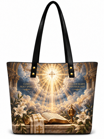 A large tote bag with black shoulder straps, featuring a detailed religious print of a radiant cross, clouds, lilies, an open Bible, and a chalice on the front, shown on a plain white background.